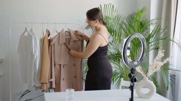 Woman in black dress arranging clothes on a rack for online selling with ring light.