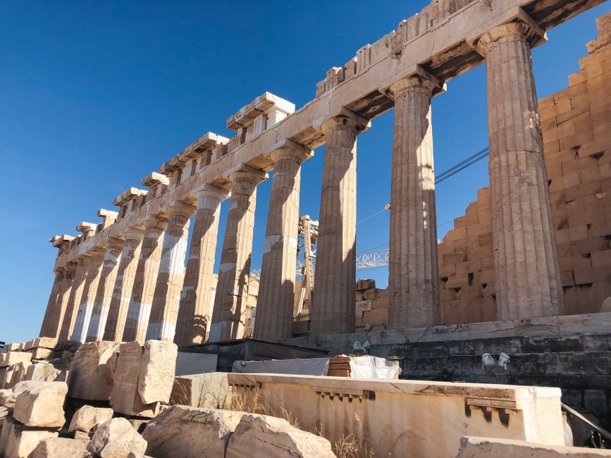 The iconic Parthenon columns in Athens, showcasing ancient Greek architecture under a bright blue sky.