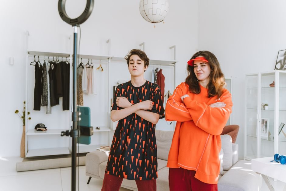 A mother and son record a fun dance video at home using a smartphone and ring light.
